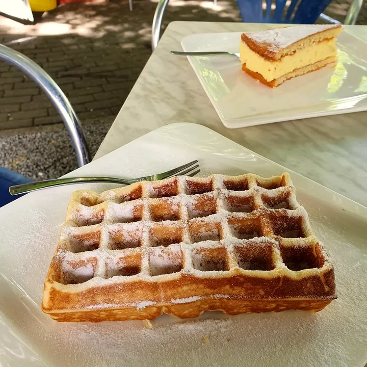 Waffel mit Puderzucker und ein Stück Torte